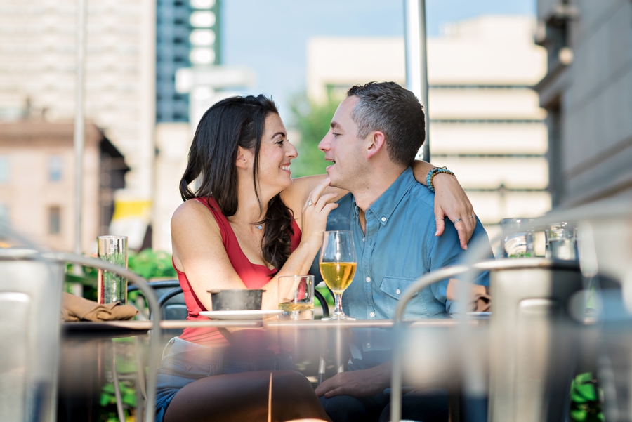 A man and woman have a drink and feed each other during their Philadelphia engagement session.